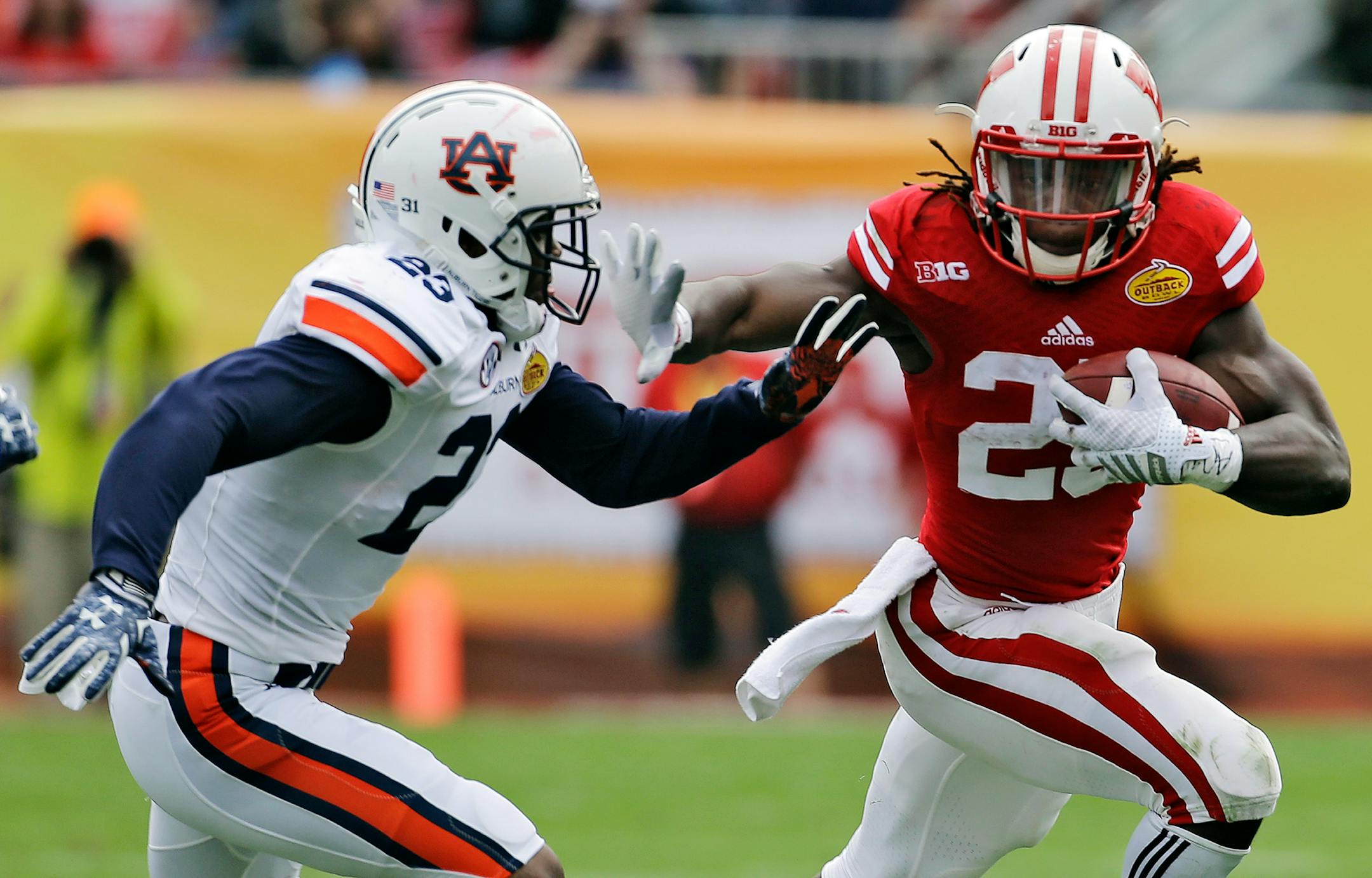 Wisconsin running back Melvin Gordon (25) stiff arms Auburn defensive back Johnathan Ford (23) on a run during the second quarter of the Outback Bowl NCAA college football game, Thursday, Jan. 1, 2015, in Tampa, Fla. (AP Photo/Chris O'Meara)