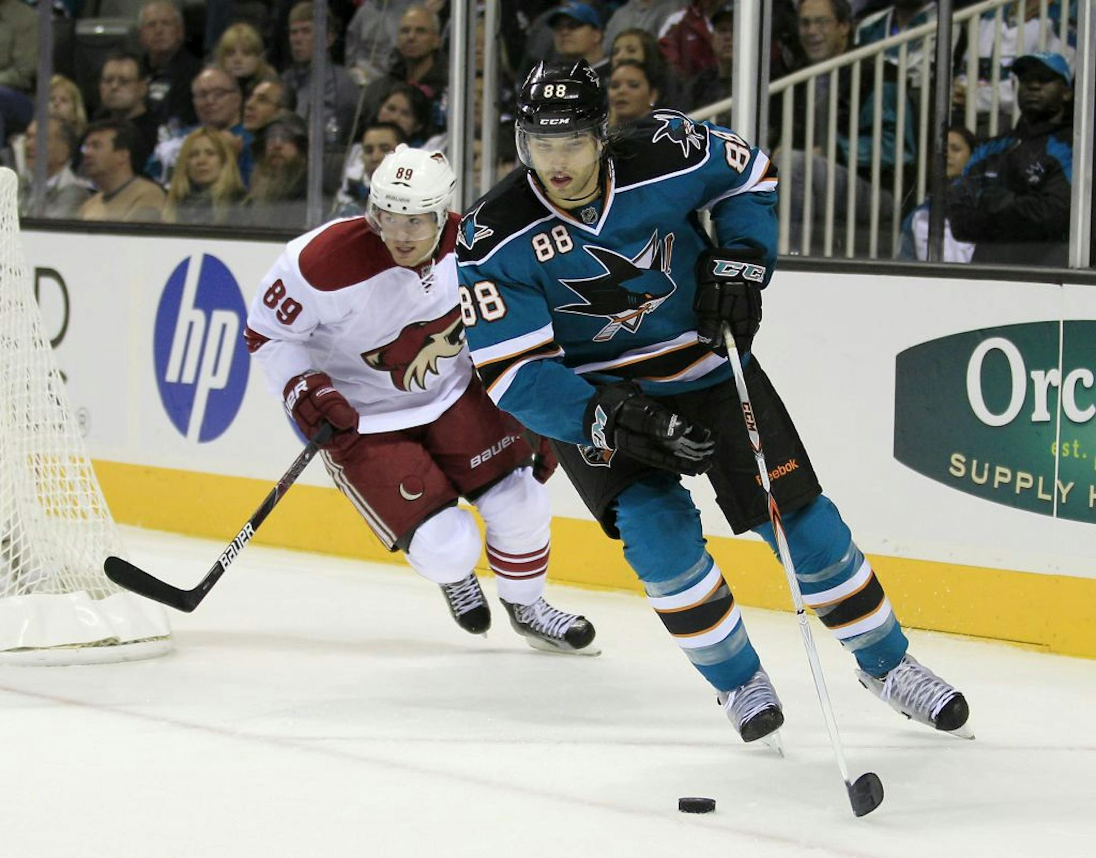San Jose Sharks defenseman Brent Burns (88) controls the puck as Phoenix Coyotes right wing Mikkel Boedker (89), of Denmark, moves in during the first period in a hockey game, Saturday, Oct. 8, 2011, in San Jose, Calif.