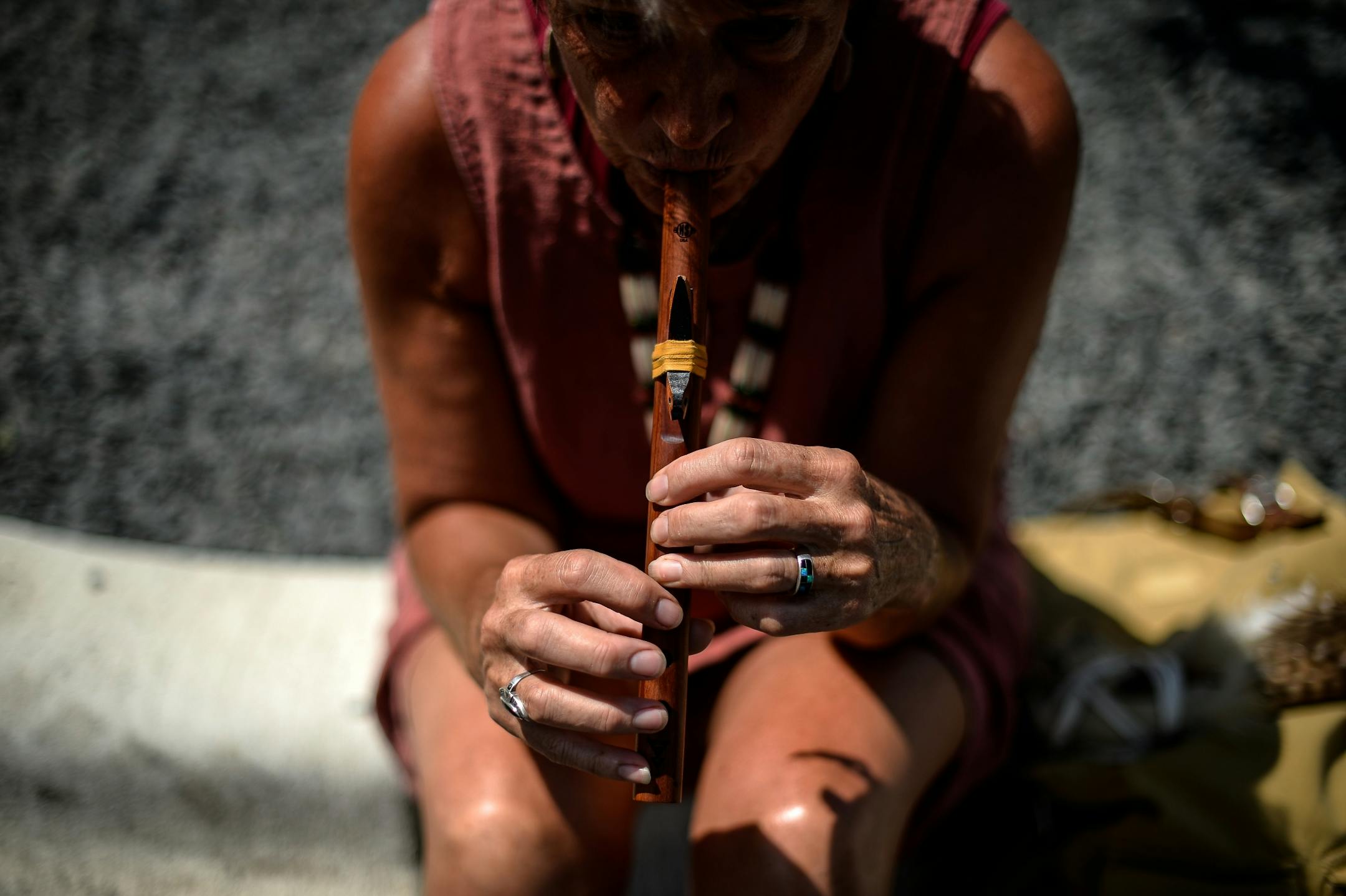 Susan Anderson, from Hudson, Wisc. and a descendent of of one of the Dakota 38, played the flute as she waited for the start of Friday afternoon's dismantling ceremony of the "Scaffold" sculpture.
