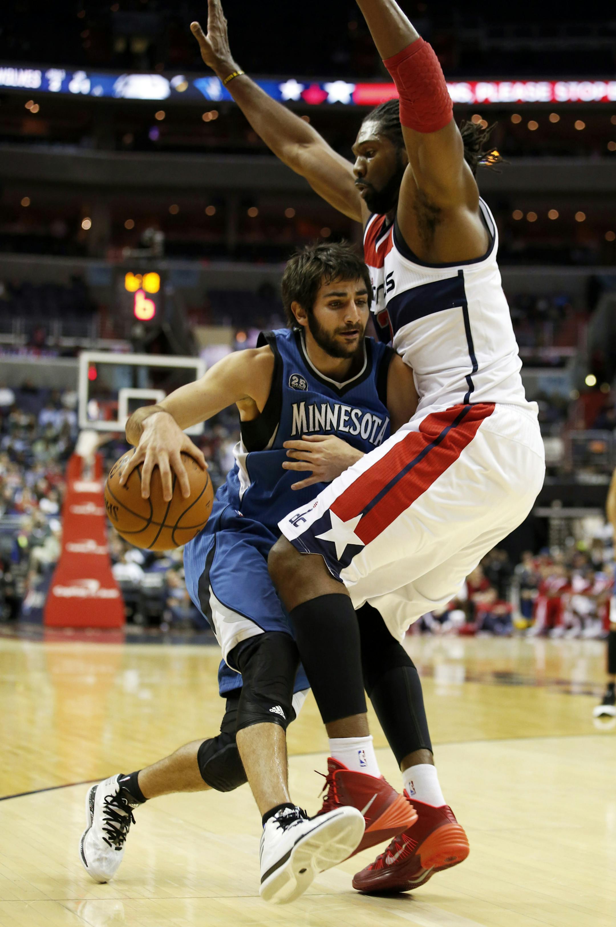 Minnesota Timberwolves guard Ricky Rubio, left, from Spain, runs into Washington Wizards forward Nene, from Brazil, in the first half of an NBA basketball game Tuesday, Nov. 19, 2013, in Washington. (AP Photo/Alex Brandon)