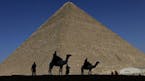 FILE - In this Dec. 12, 2012 file photo, policemen are silhouetted against the Great Pyramid in Giza, Egypt. Scientists have found a previously undisc
