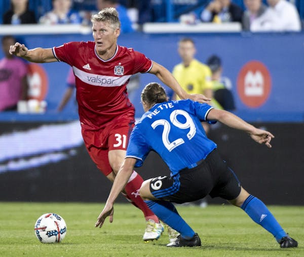 Chicago Fire midfielder Bastian Schweinsteiger plays the ball away from Montreal Impact midfielder Samuel Piette during the first half of an MLS socce
