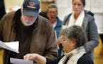 Michael Parent, left, gets instructions on submitting his ballots from warden Denise Shames while voting Tuesday, Nov. 7, 2017, in Portland, Maine. Vo