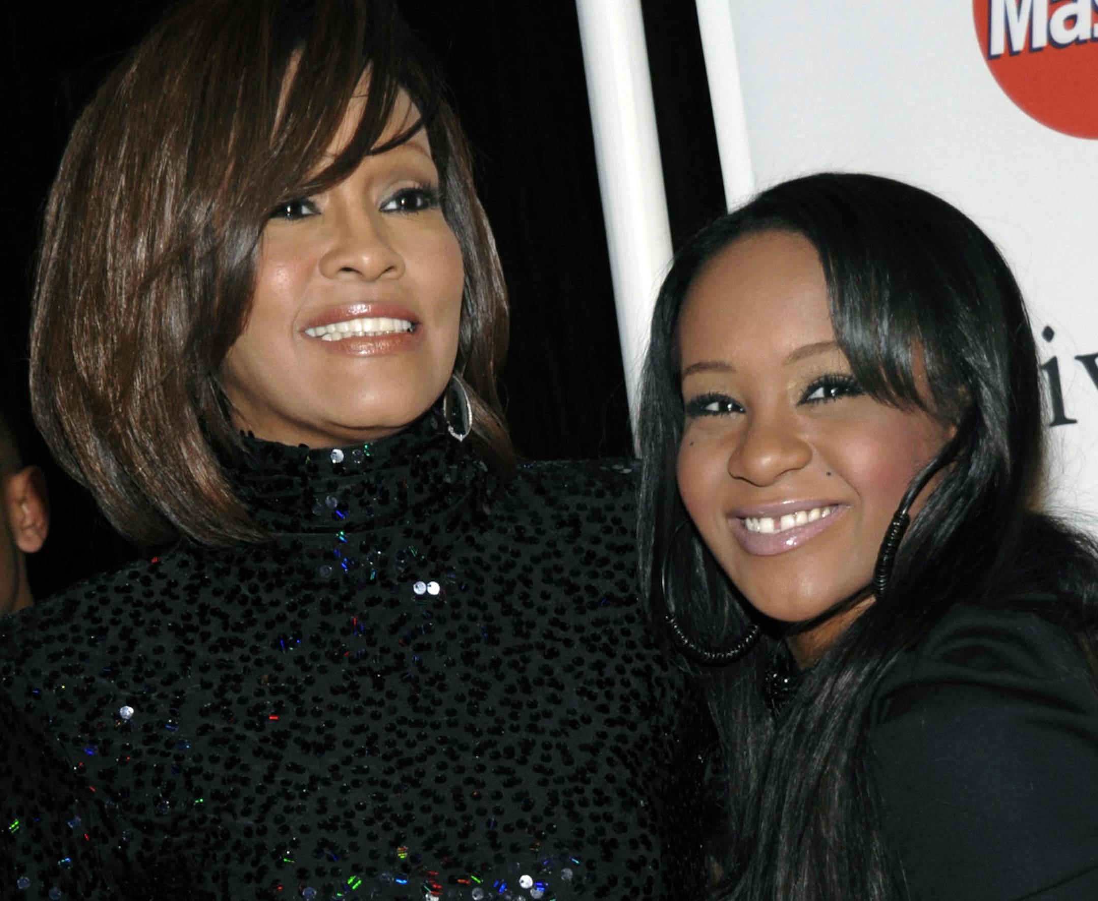 FILE - In this Feb. 12, 2011, file photo, singer Whitney Houston, left, and daughter Bobbi Kristina Brown arrive at an event in Beverly Hills, Calif. Bobbi Kristina, who dreamed of growing up to achieve fame like her mother, died in hospice care July 26, 2015, about six months after she was found face-down and unresponsive in a bathtub in her suburban Atlanta townhome. For Houston fans, the scene was grimly similar to the way her megastar mother had died three years earlier. (AP Photo/Dan Steinb