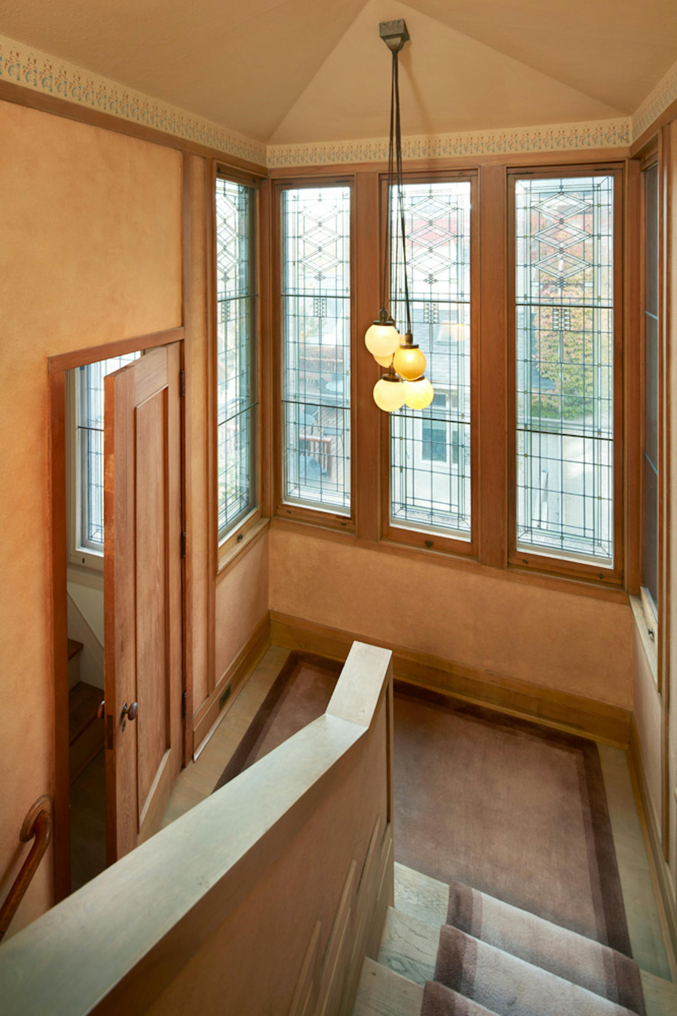 Purcell-Cutts House, 2328 Lake Place, Minneapolis, Minnesota, 1913, William Gray Purcell, Architect.George Elmslie, George Feick Jr. partners in firm Purcell, Feick and Elmslie, Edna S. Purcell House, Prarie School Style, Open floor plan, Art Glass windows, Writing Nook, Fireplace wall Mural by Charles Livingston Bull, Louisana Herons Flying with two Moons, Iridescent glass mortered in frieplace base, Stencil pattern, Peak a Book stained glass entry, Grandfather Gray portrait by Lawton Parker in Entrance Hall, Dining room Art Glass double door to screend-in Porch, Reflecting Pool and landscape designed by Harry Franklin Baker, Living room, Stair Hall, Master Suite, Sleeping Porch, Built in cedar floor storage, fireplace, childrens room connected to master with accordian style operating partition, sunken Living room,tent Ceilings, Ceiling Lights and art glass by Mosaic Art Shops Minneapolis, Maid Call Button, Air conditioning, Central vacuum system, sliding kitchen door operated by foot button, icebox in kitchen with door to outside, custom Sitting chair, Custom Floor lamp, Custom Dining room table,chairs and sideboard, Custom Cluster Pendant lighting, Oak hardwood floors and trim, Custom Throw rugs, Continuous tented roof and ceiling, Elevated dining room, dropped floor living room, "Little Joker", Personalized home with monogram ESP for Edna S. Purcell,