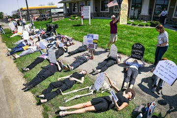 Demonstrators gathered at the Burnsville offices of Minnesota Republican congressman Jason Lewis in the wake of his vote on Thursday to repeal and rep