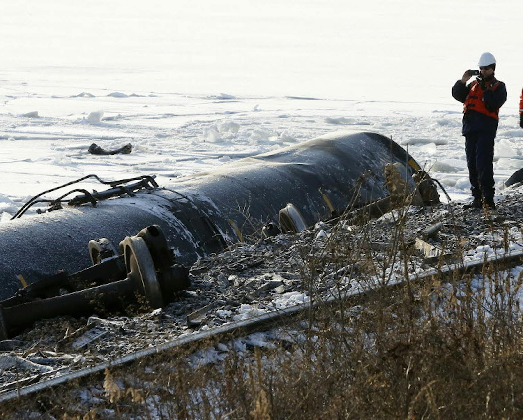 Crews work the scene of a train derailment Wednesday, Jan. 27, 2016, along Hwy. 26 south of Brownsville, Minn. Authorities say two of six derailed train cars have broken through the ice on the Mississippi River in southeastern Minnesota. (Andrew Link/The Rochester Post-Bulletin via AP) MANDATORY CREDIT TRAIN DERAILMENT MISSISSIPPI RIVER Andrew Link