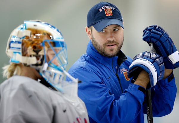 Finland assistant women's hockey coach Andy Kent and goalie Noora Raty during team practice on Friday in Sochi, Russia.