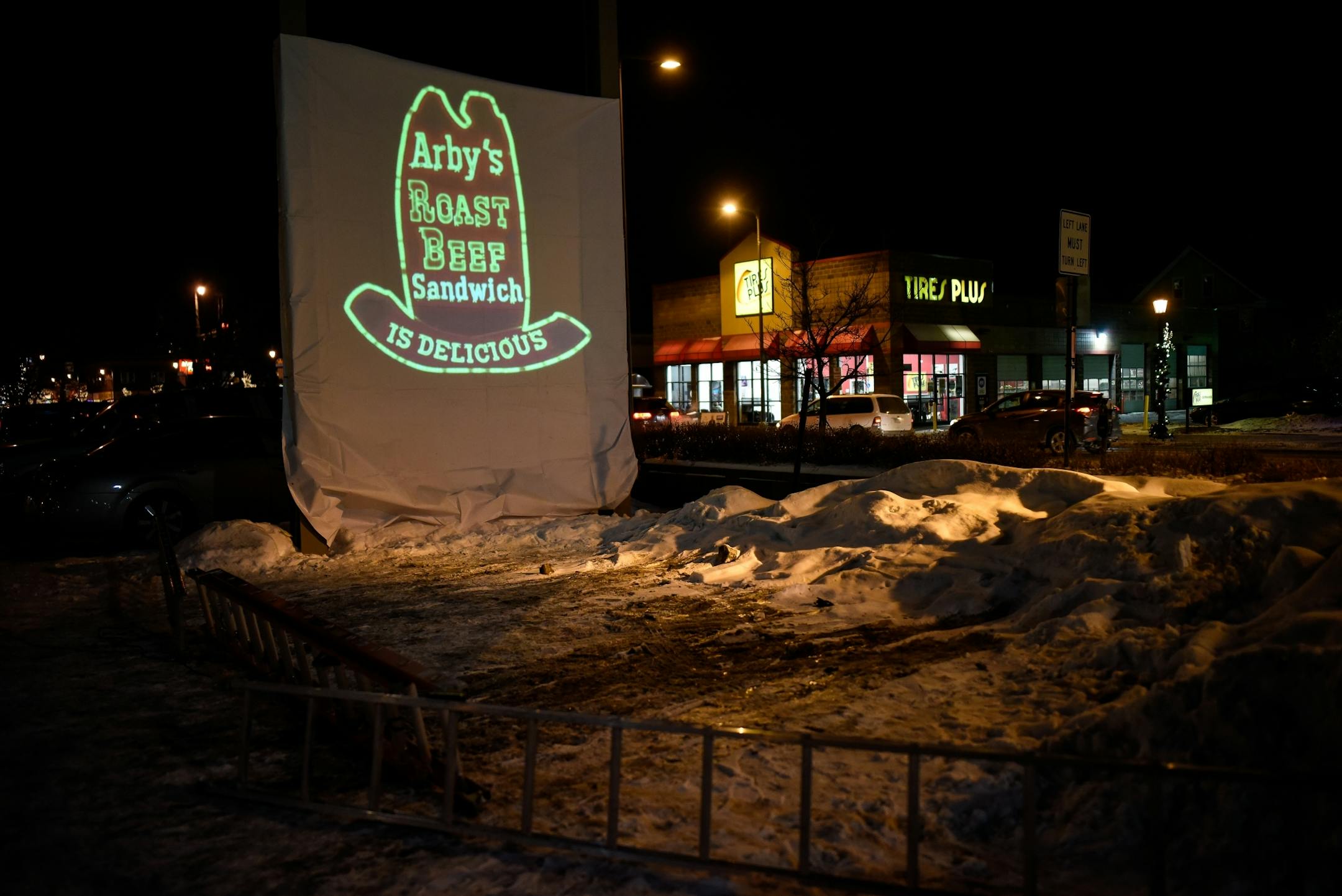 A projected Arby's logo was put in place of the original Uptown Arby's sign for Friday night's vigil.