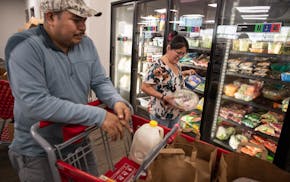 Chris and Antonia Ramirez pick up some grocery items for their family of four at the Open Door food pantry in Eagan, Thursday, May 15, 2025.