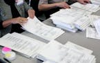 Ramsey County election officials count ballots into piles of 25 on Friday.