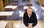 New York Times columnist Thomas Friedman poses for a photo while sitting in his old seat in his old journalism classroom at St. Louis Park High School