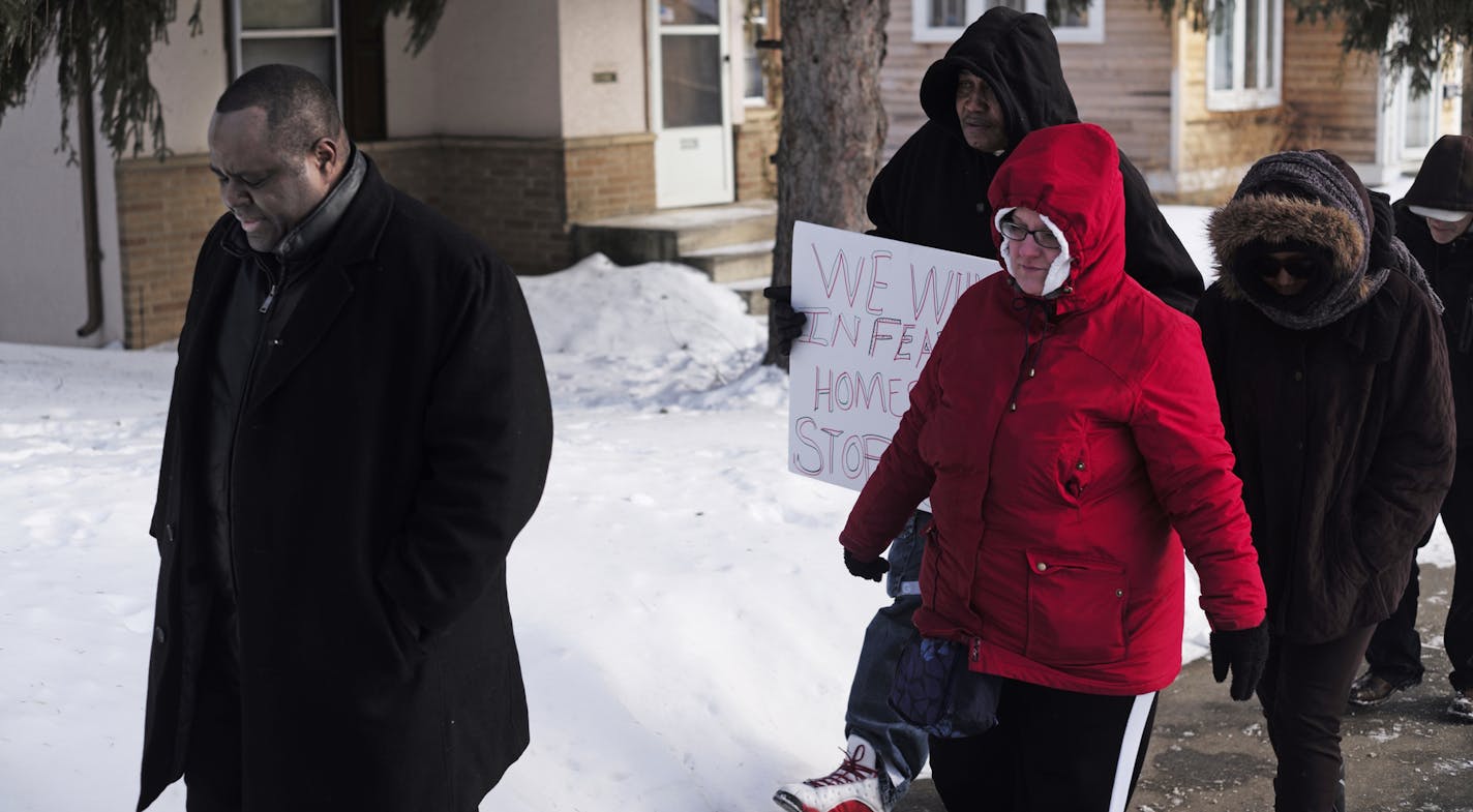 Pastor Harding Smith, left, led a group in prayer Thursday to &#x201c;claim our neighborhood back from fear and mistrust&#x201d; when a good Samaritan opening his door was killed Jan. 31 in his home. Two by two, people went door to door on the border of the McKinley-Camden neighborhoods, talking to residents and handing out cards with information about how to report crime anonymously.