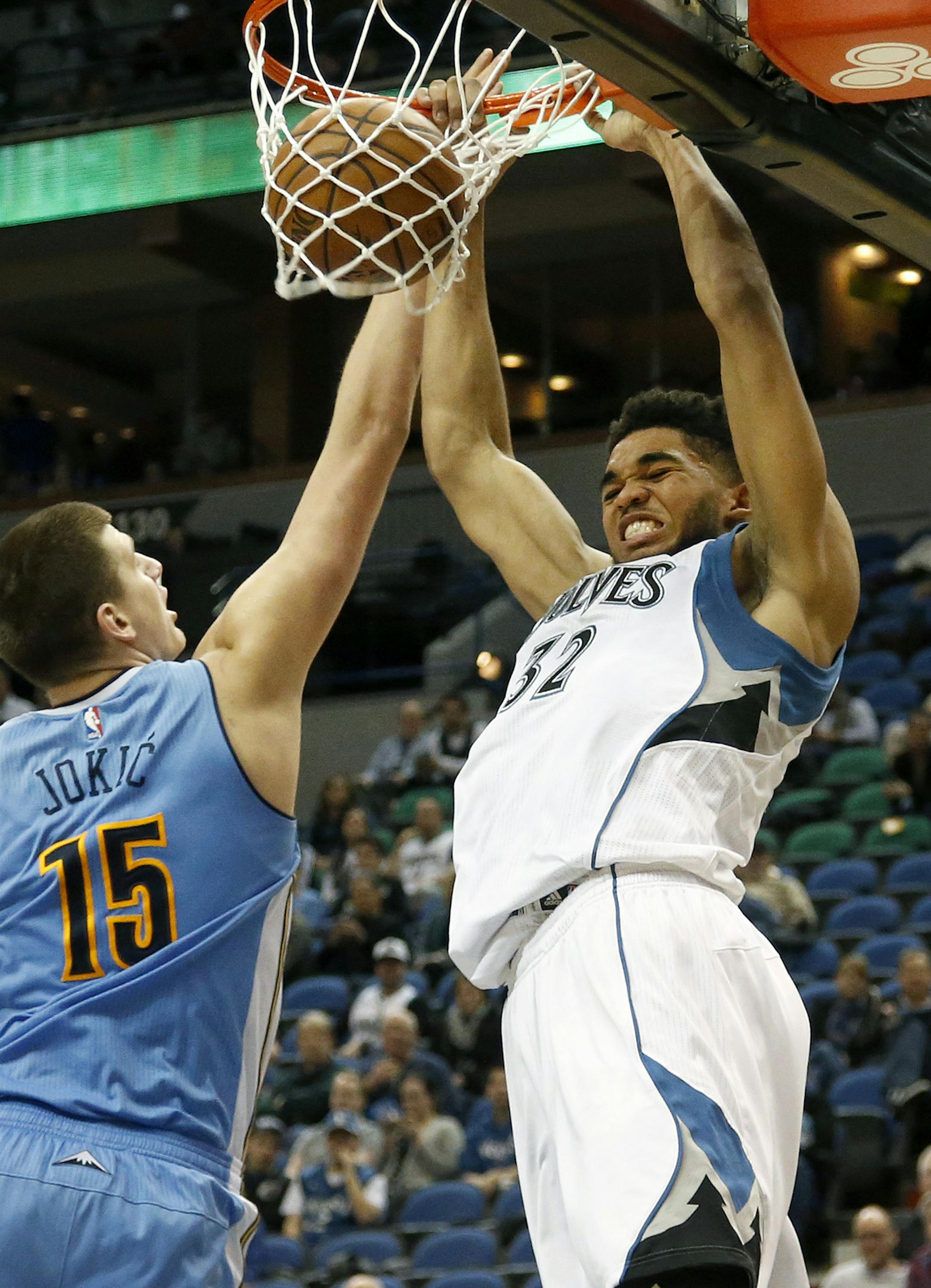 Karl-Anthony Towns (32) dunked the ball while being defended by Nikola Jokic (15) in the second quarter.