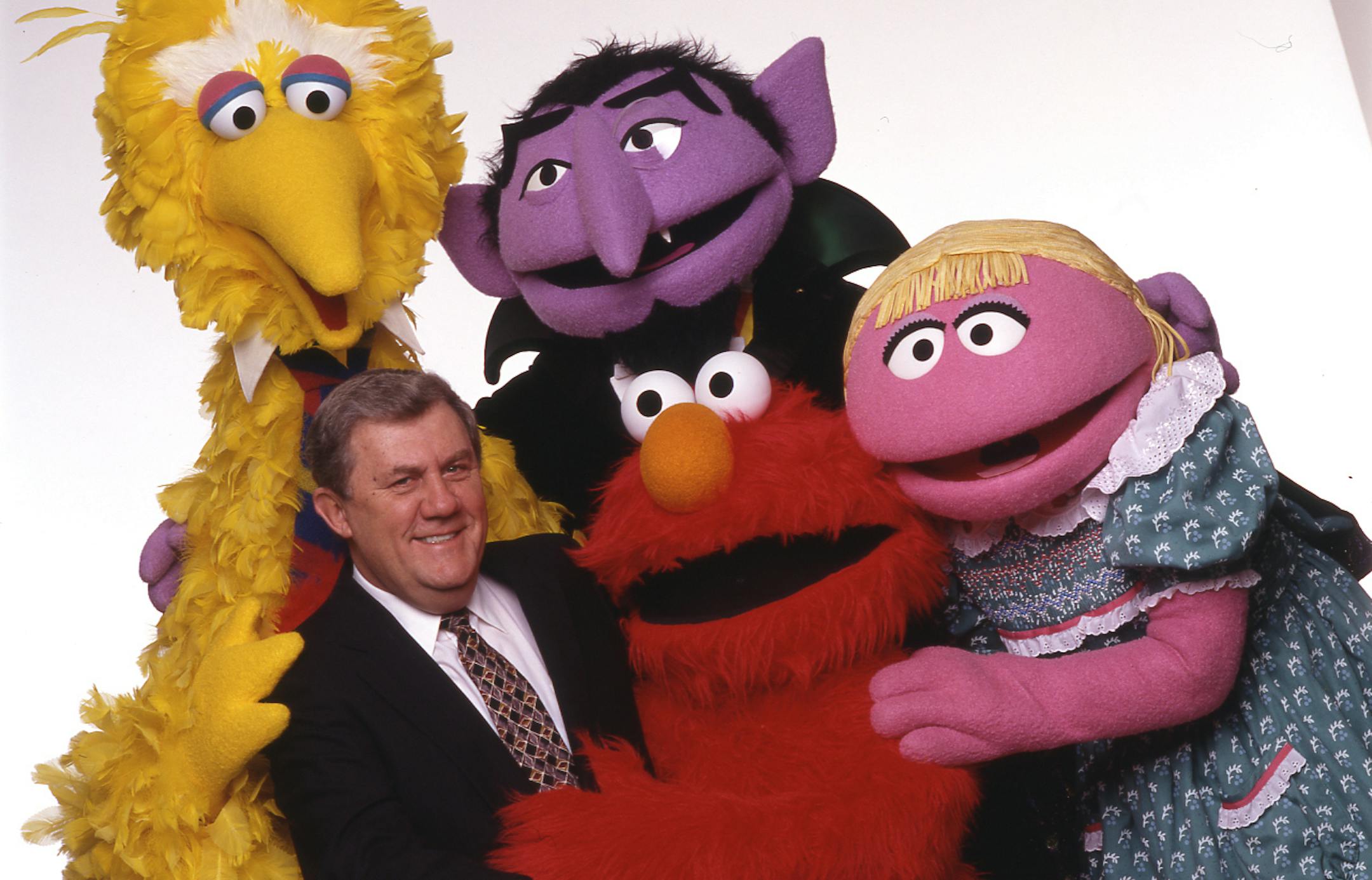 Photo of Bince Egan with some cast members of Sesame Street.