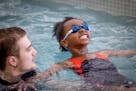 Sam Austin, a St. Cloud YMCA swim instructor, teaches a  Madison Elementary second-grader how to float on her back in the pool.