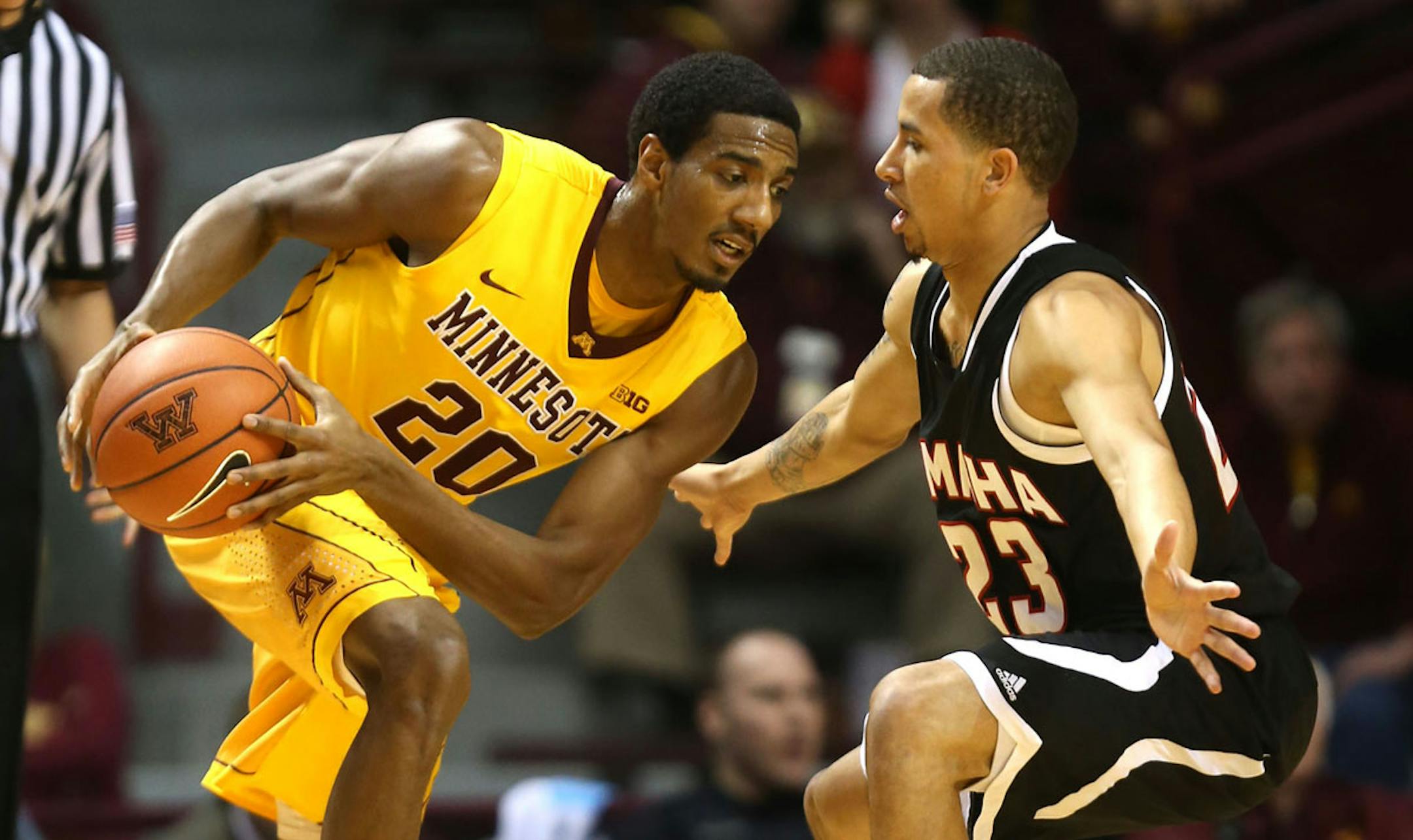 Gophers senior Austin Hollins drove to the basket with Nebraska’a Omaha’s Marcus Tyus, an Anoka High School product, defending during the first half Friday night.