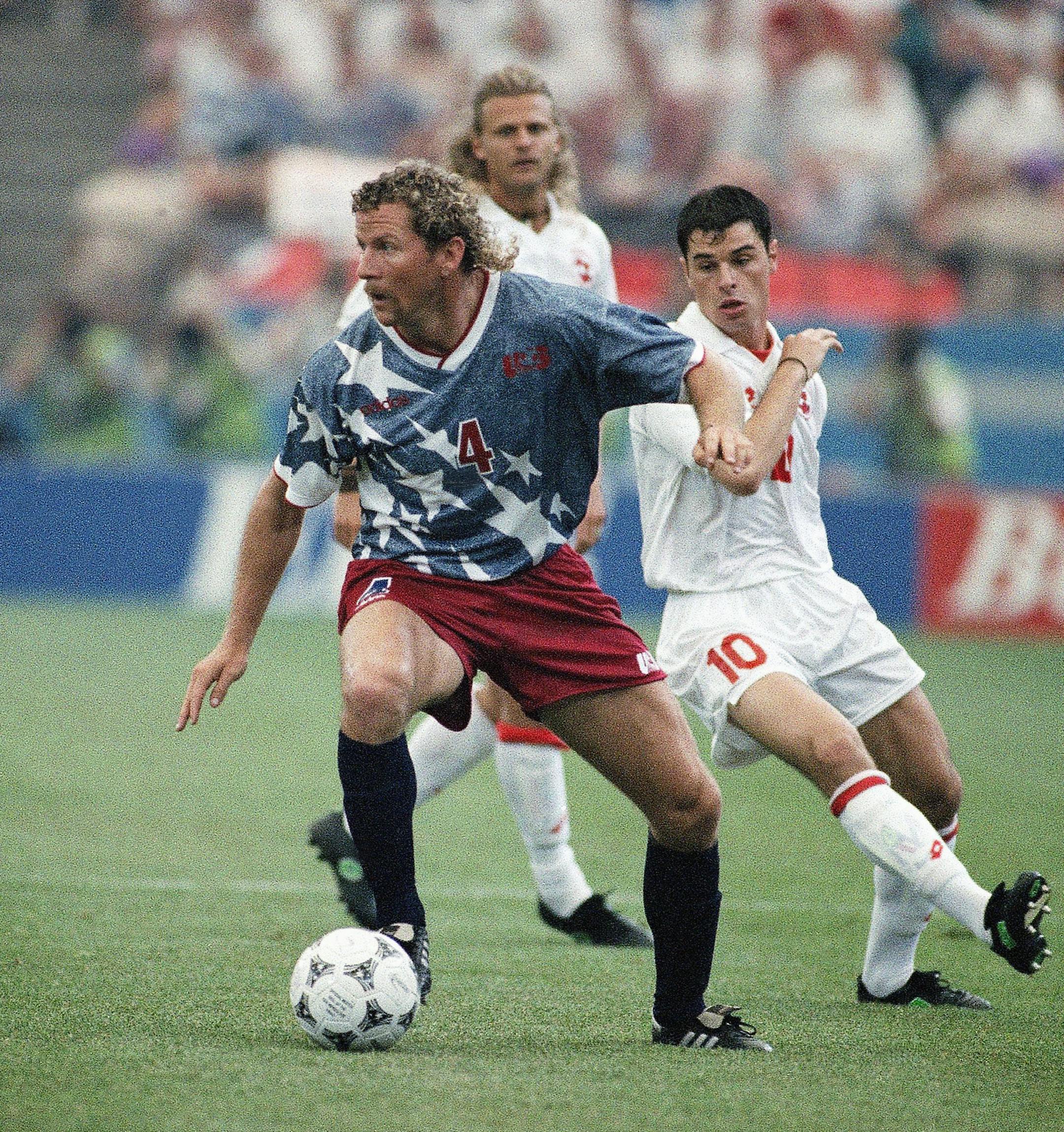 United States national team defender Cle Klooman, left, maneuvers away from Swiss midfielder Ciriaco Sforza during the United States vs. Switzerland World Cup soccer championship Group A match at the Pontiac Silverdome, on Saturday, June 18, 1994. Background is Switzerland?s Alain Sutter. (AP Photo/Rudi Blaha) ORG XMIT: APHS212396