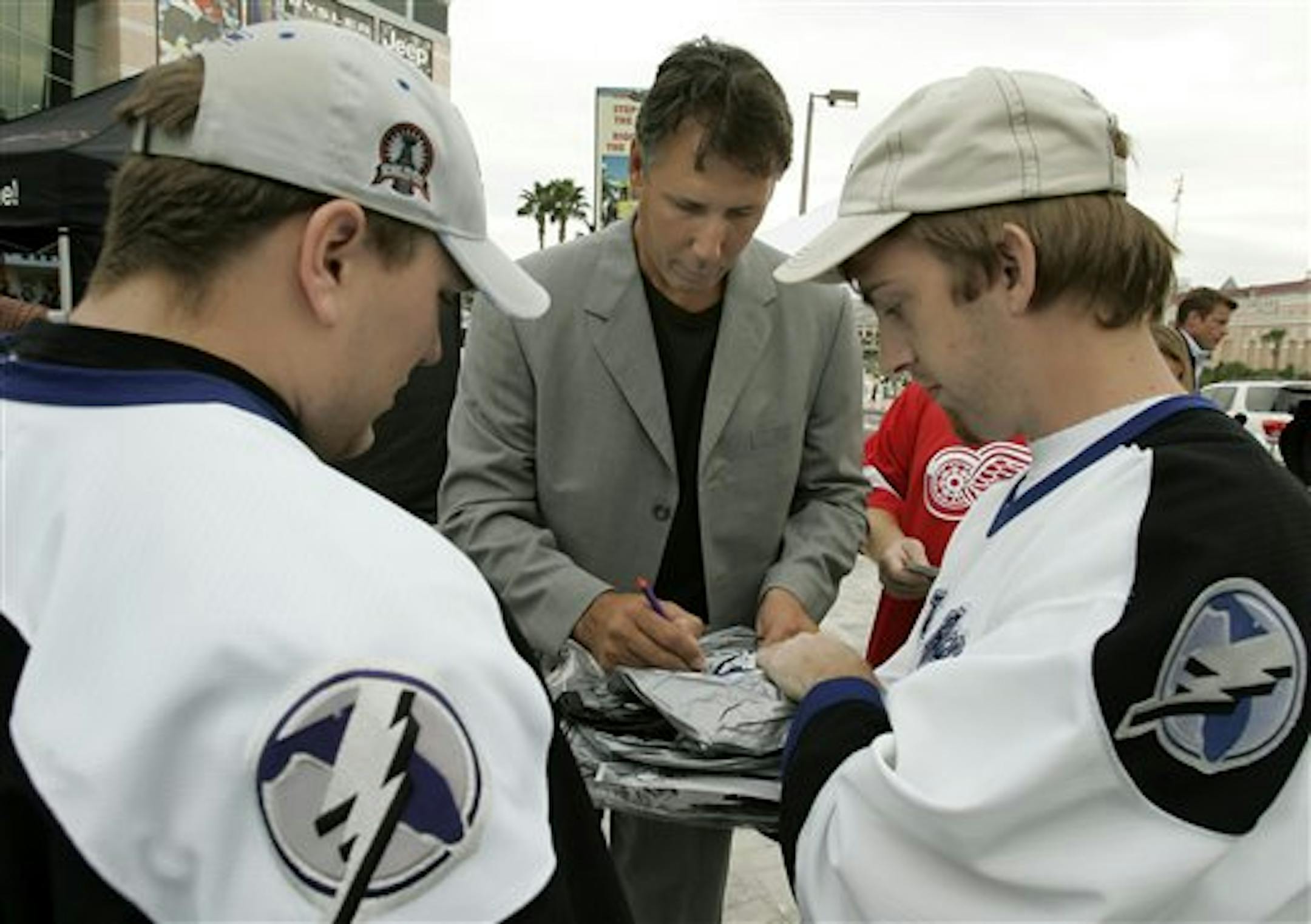 Former Tampa Bay Lightning captain Dave Andreychuk, center, signs autographs for fans after being named a community representative Thursday night Sept. 28, 2006, in Tampa, Fla. Andreychuk, who has now officially retired as a player, played in 1,639 games in his career and is the NHL's all-time leader in power play goals.