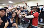 FILE -This Jan. 13, 2016 file photo shows 7-Eleven store clerk M. Faroqui celebrates with customers after learning the store sold a winning Powerball 