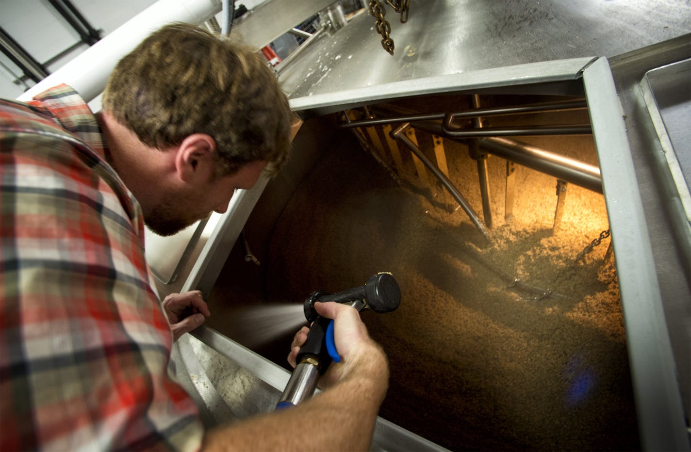 Tom Whisenand, director of operations and co-founder at Indeed Brewing Company, Minneapolis, helped clean a tank during the graining out process where spent malt is removed. The beer business is booming in Minnesota, and it was the state Legislature that opened the taps. Since lawmakers allowed brewers to open taprooms on their premises, Minnesota has enjoyed the nation's second-highest growth of craft brewing. Tuesday, June 25, 2013. ] GLEN STUBBE * gstubbe@startribune.com