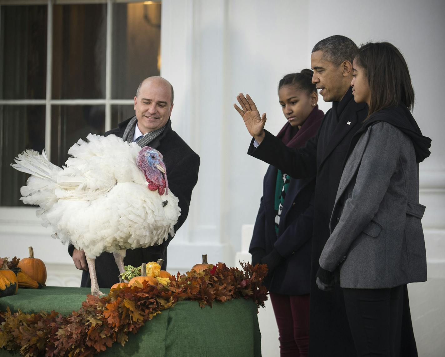 President Barack Obama pardons Popcorn, the National Thanksgiving Turkey, with his daughters, Sasha, left, and Malia, at the White House in Washington, Nov. 27, 2013. The president also pardoned Caramel, the runner-up for National Thanksgiving Turkey. (Gabriella Demczuk/The New York Times) ORG XMIT: MIN2013112716175069