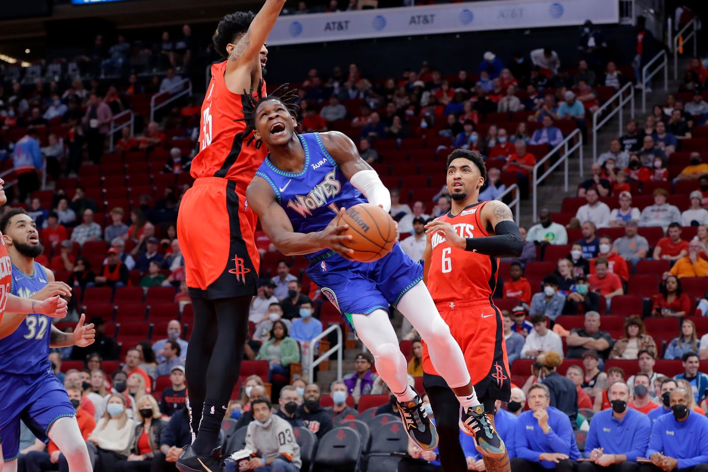 Timberwolves forward Anthony Edwards drives to the basket in front of Rockets center Christian Wood, left, and forward Kenyon Martin Jr.