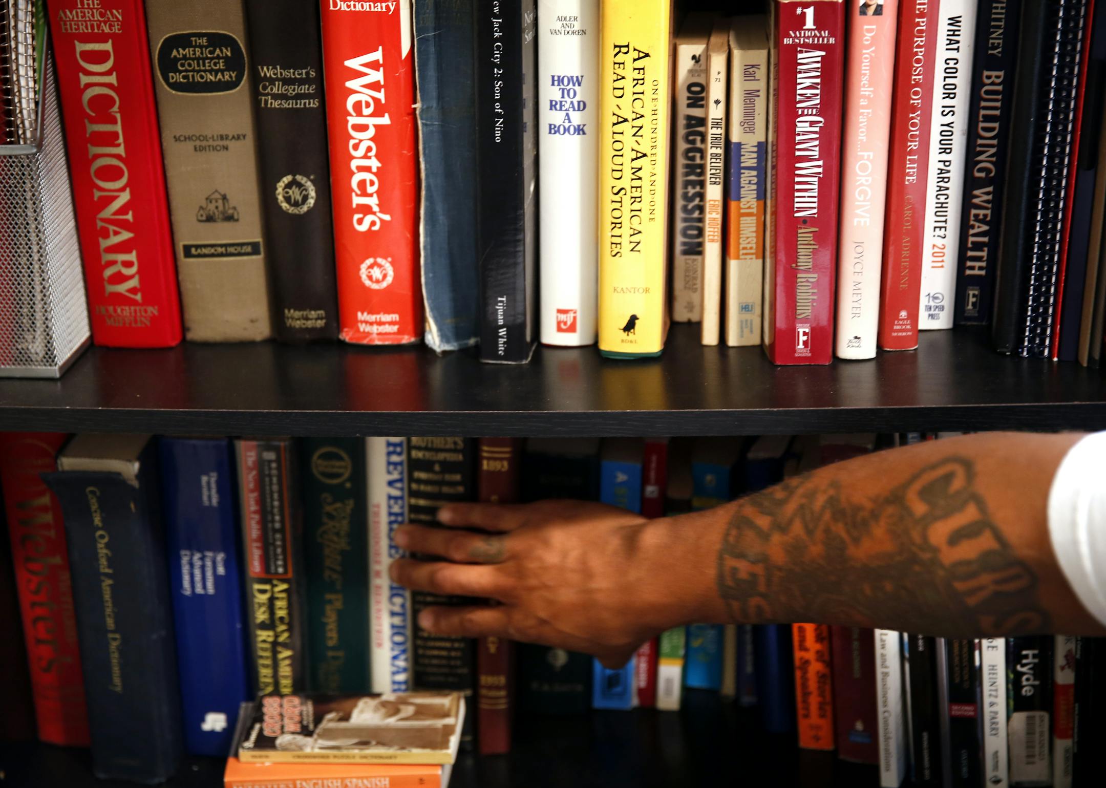 Albert Joseph Briscoe shows off his large collection of dictionaries. "The dictionary is my best friend," said Briscoe, who learned to love reading while serving time in prison. ] LEILA NAVIDI leila.navidi@startribune.com / BACKGROUND INFO: Friday, October 3, 2014. Albert Joseph Briscoe officially got off parole September, 28, 2014 and has been out of prison since June 2012. Briscoe, a member of the Vice Lords gang, has founded a literacy program called To Succeed You Must Read and has written s