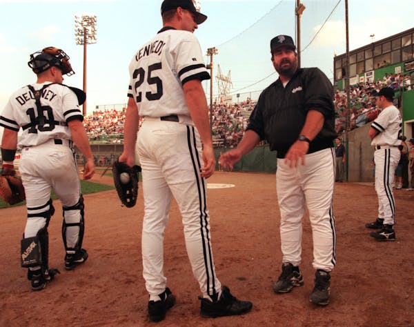 Former Saints manager Marty Scott, right, directs his players at Midway Stadium in the 1990s.