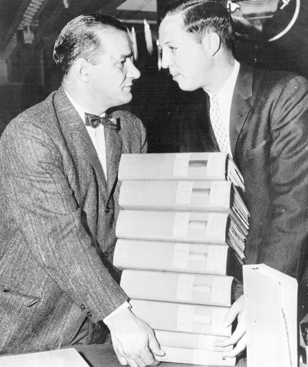 Sid Gillman, left, coach of the Los Angeles Rams, and Pete Rozelle carry books of data about college players for the NFL draft in 1957. 