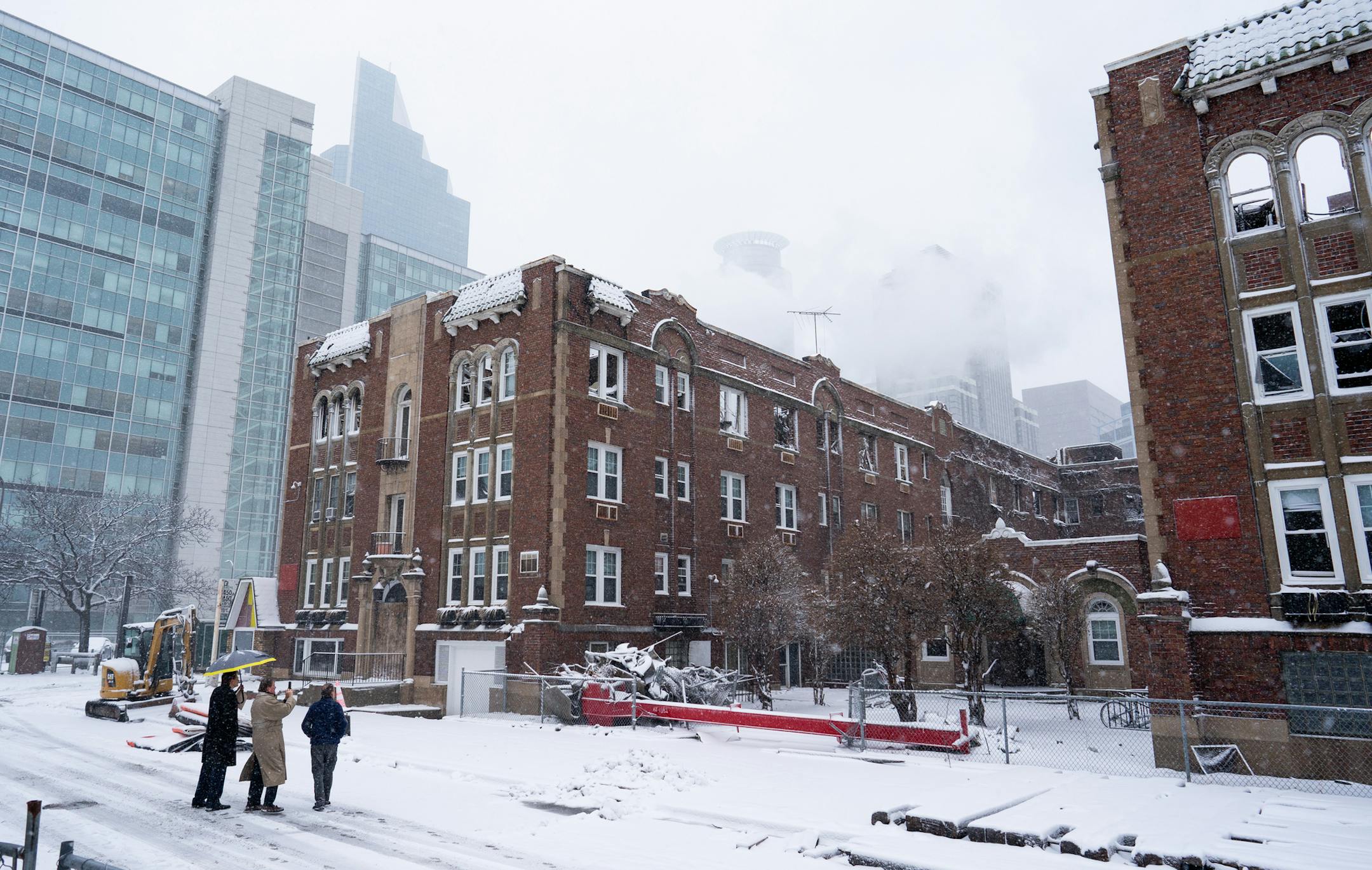 Crews worked though heavy snow, slowly knocking down walls abutting a neighboring garage that was undamaged by the fire. ] MARK VANCLEAVE ¥ Workers ripped down walls of the burned Francis Drake Hotel on Monday, Dec. 30, 2019 in Minneapolis.