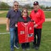 From left, Steve Branca, Mary Branca Rosenow and Denny Branca show off the framed uniform that the Rochester John Marshall baseball program gave them 