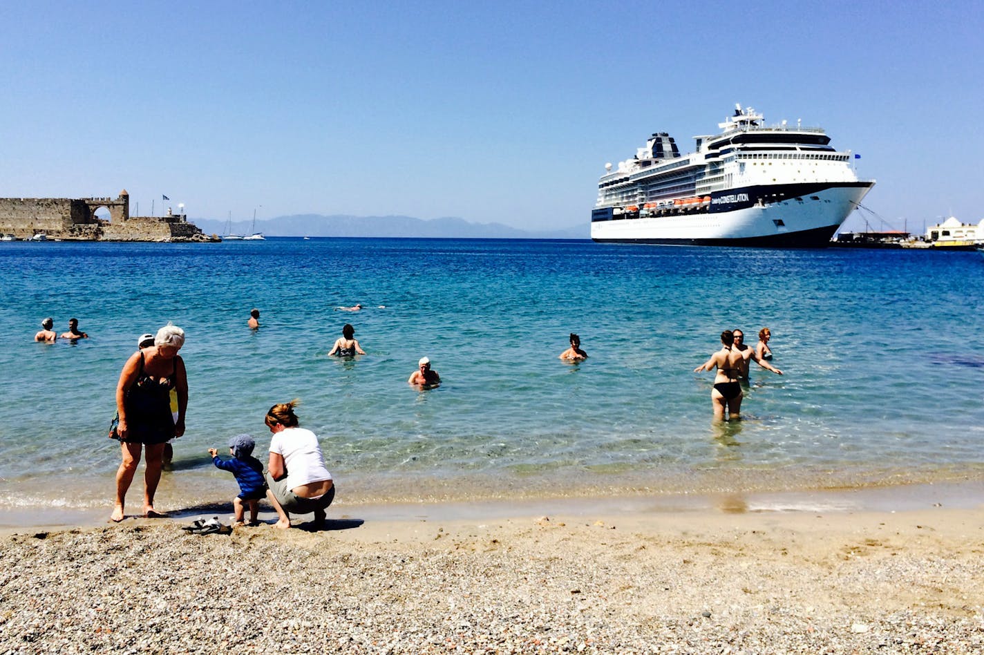 The Celebrity Constellation looms in the background from a city swimming beach on the Greek Island of Rhodes.