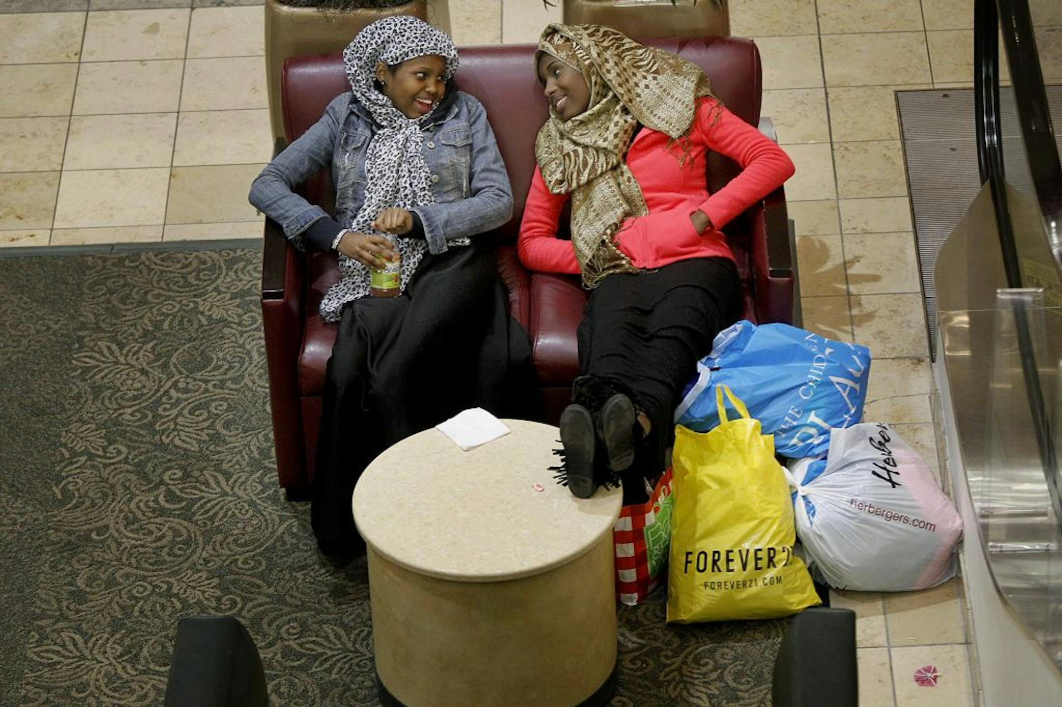 Imani Adani, left, and Ifrah Hashi of Minneapolis found a spot to take a break from shopping since 12 a.m. at Rosedale Mall, Tuesday, November 20, 2012 in Roseville, MN. (ELIZABETH FLORES/STAR TRIBUNE) ELIZABETH FLORES � eflores@startribune.com