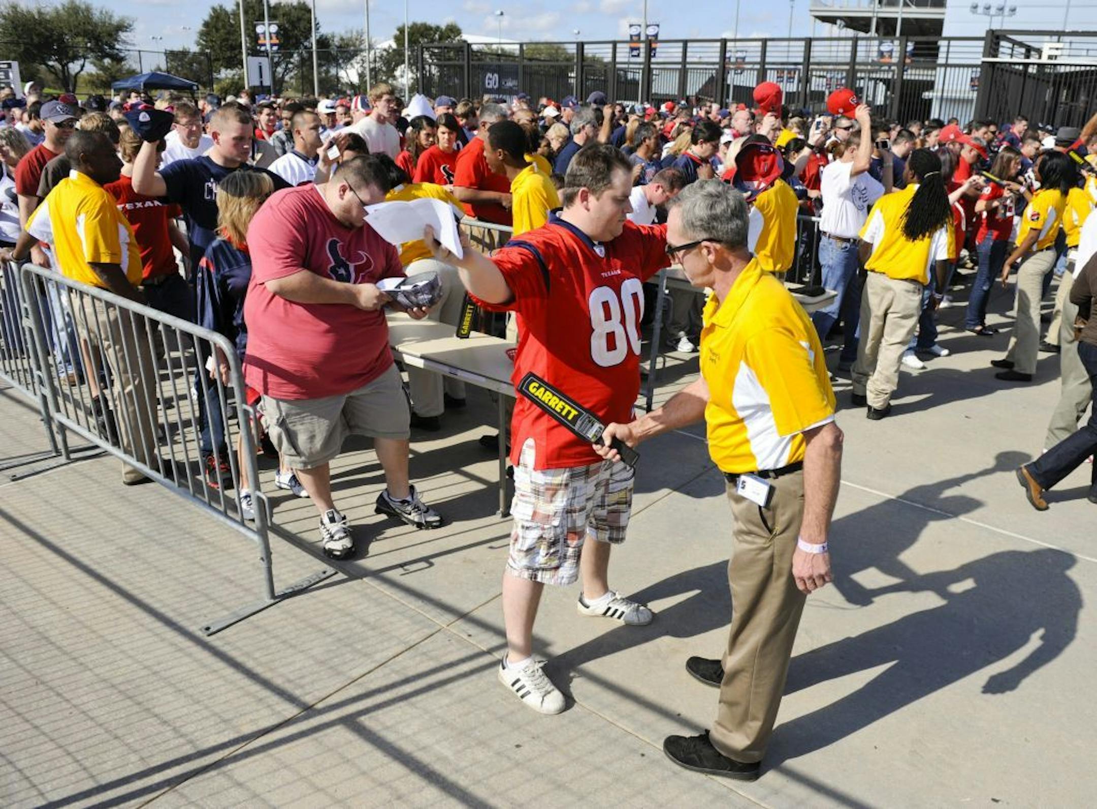 FILE - In this Jan. 7, 2012, photo, fans go through a security checkpoint as they enter the stadium for an NFL wild card playoff football game between the Cincinnati Bengals and Houston Texans in Houston.