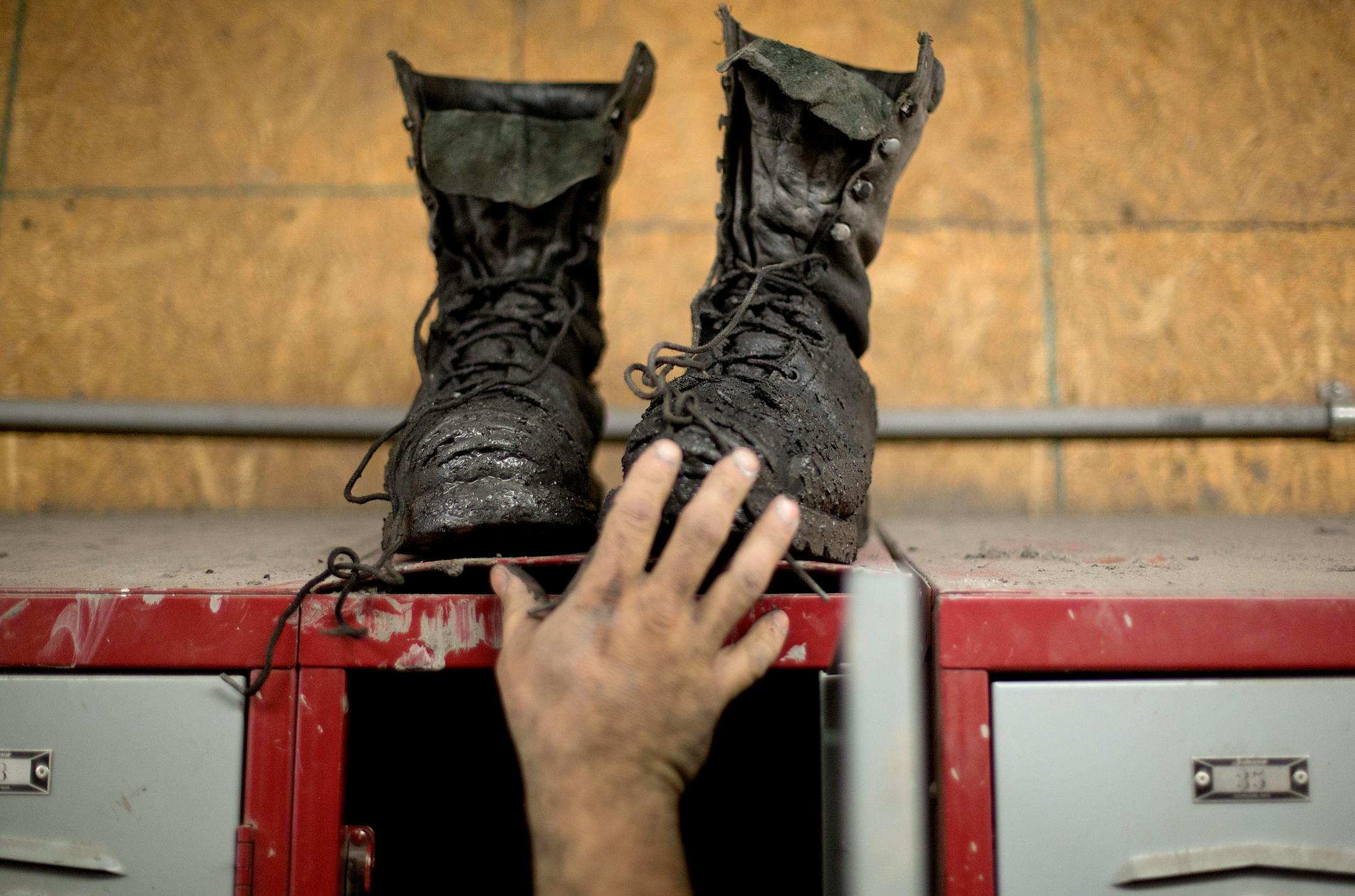 In this Oct. 15, 2014 photo, coal miner Johnny Turner, 35, puts his coal boots on top of his locker after finishing a shift underground at the Perkins Branch coal mine in Cumberland, Ky. Since January 2012, the state has lost more than 7,000 direct mining jobs, some of the most lucrative in this part of the country. Mine employment in Kentucky is at its lowest levels since the Great Depression. (AP Photo/David Goldman)