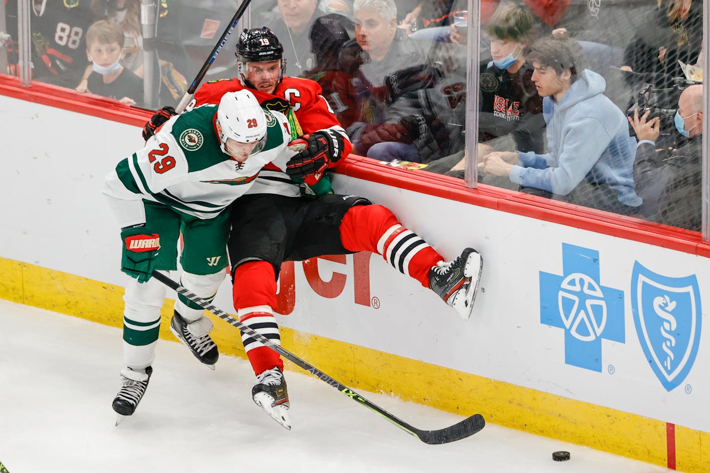 Minnesota Wild defenseman Dmitry Kulikov (29) battles for the puck with Chicago Blackhawks center Jonathan Toews (19) during the second period of an NHL preseason hockey game, Saturday, Oct. 9, 2021, in Chicago. (AP Photo/Kamil Krzaczynski)