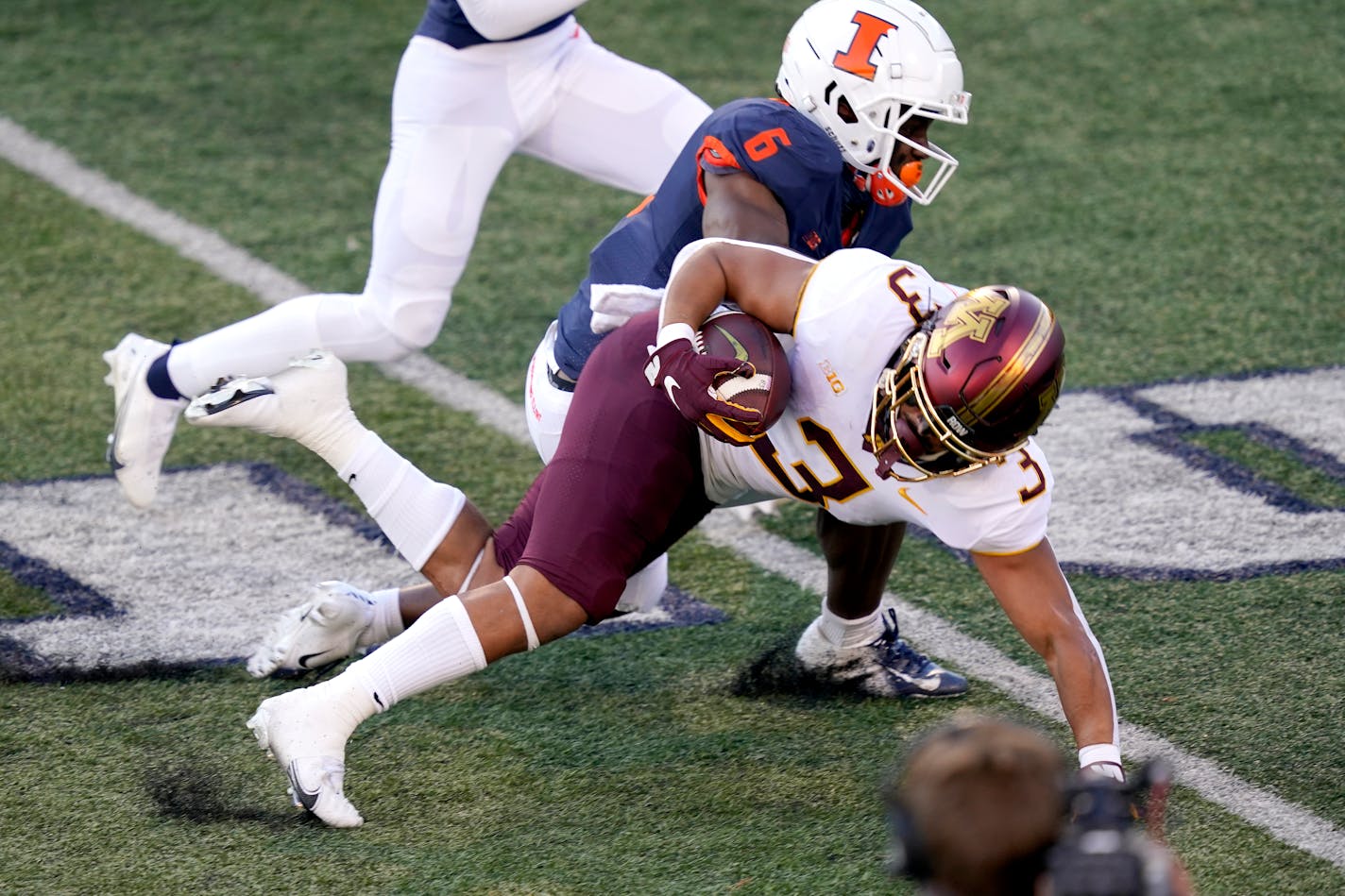 Gophers running back Treyson Potts is tackled by Illinois defensive back Tony Adams during the first half