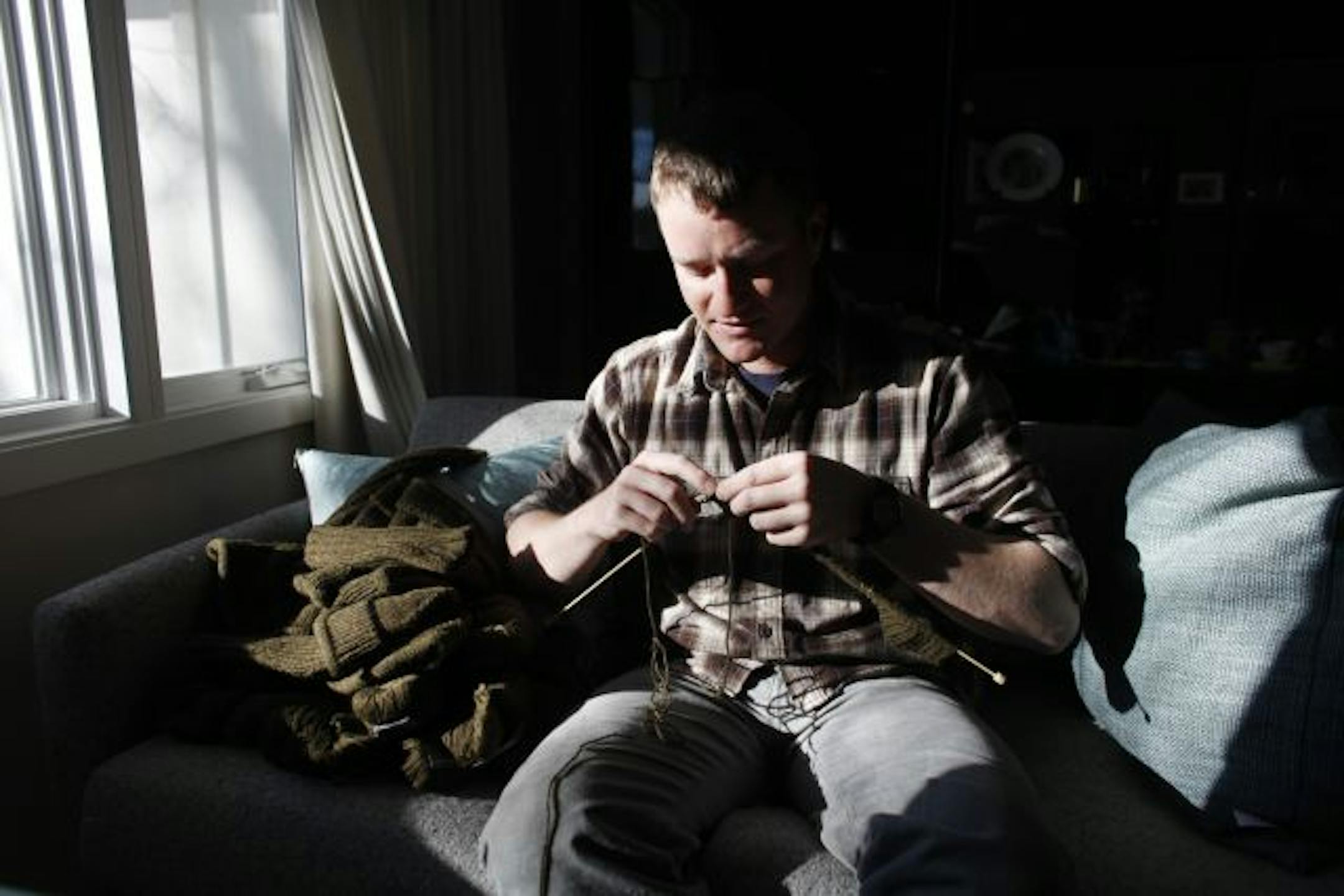 Staff Sgt. John Sorich knitted a sweater in his mom�s living room in Eden Prairie. Sorich was part of a knitting group of Army men and a few women during his recent his 11-month tour in Iraq.