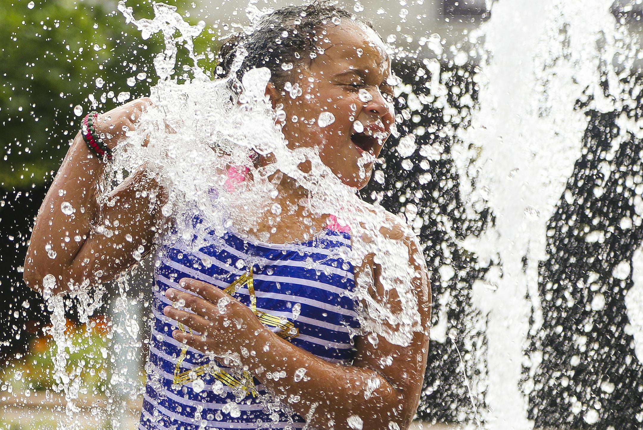LaRyssa Shead, 7, reacts after being sprayed with water at a fountain outside Hughes Pavilion. ] Timothy Nwachukwu &#x2022; timothy.nwachukwu@startribune.com Visitors enjoy a warm Minnesota summer afternoon at Centennial Lakes Park on Wednesday, July 20, 2016 in Edina. The development was recognized as one the the Great Places of 2014 by the Sensible Land Use Coalition.