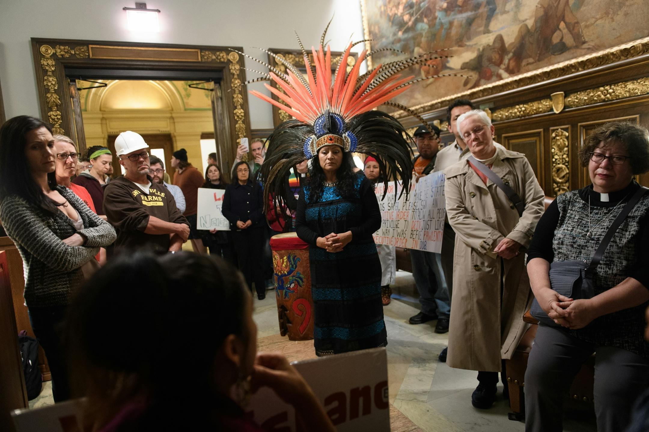 Immigrant rights activists from the Minnesota Immigrant Rights Action Committee (MIRAC) and religious activist group, Isaiah, gathered outside Gov. Mark Dayton's office Tuesday afternoon. In the center, MIRAC's Susana de Leon wearing a central American head dress.