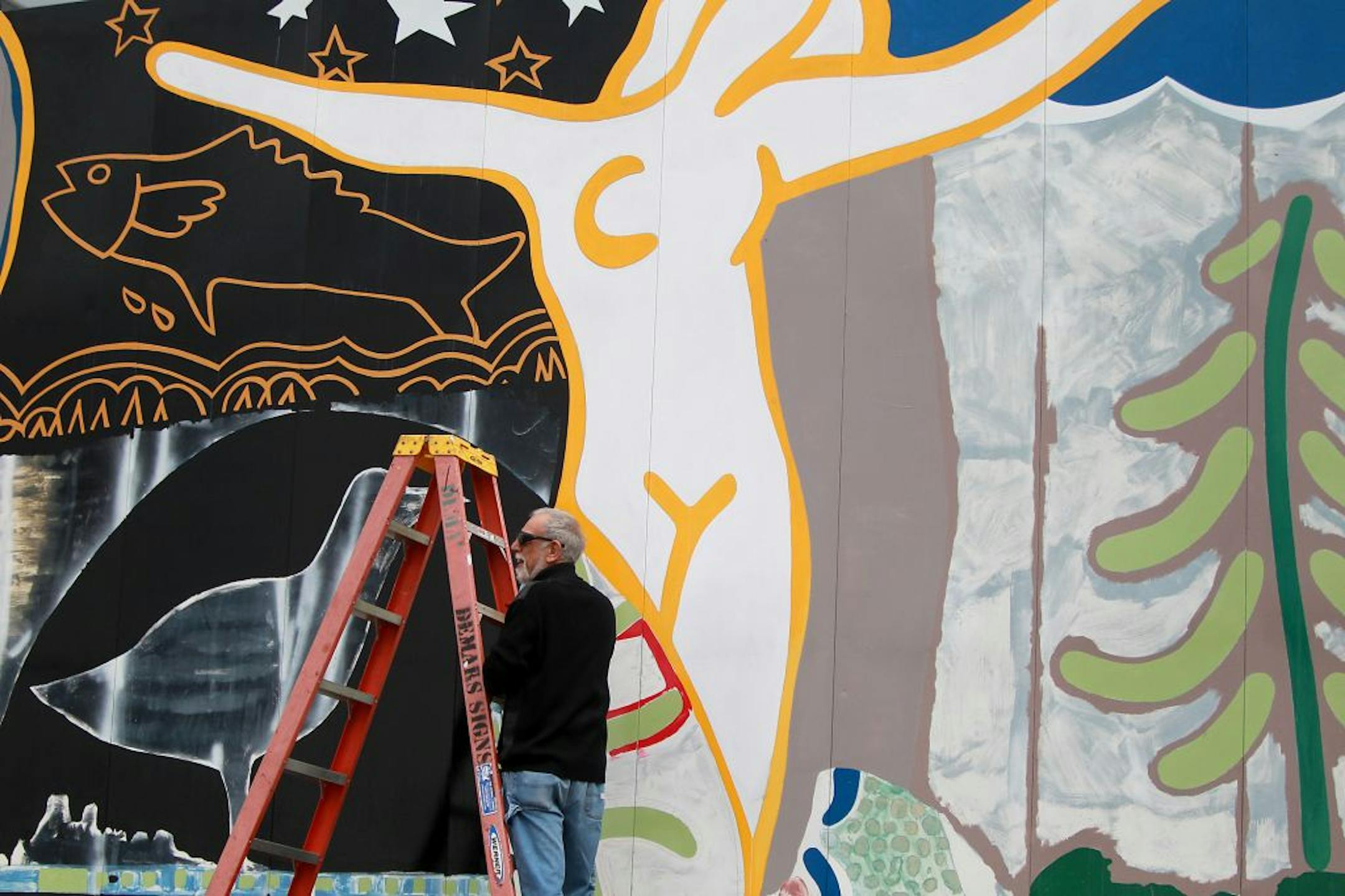 Minneapolis artist Leon Huscha worked on restoring his 1984 mural.