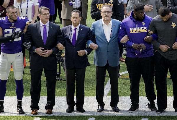 Minnesota Vikings general manager Rick Spielman, owners Mark Wilf and Zygi Wilf stood with players Harrison Smith (22) (left) during the National Anth