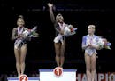 All-around winner Simone Biles, center, stands on the podium with second place finisher Sunisa Lee, left, and third place finisher Grace McCallum afte