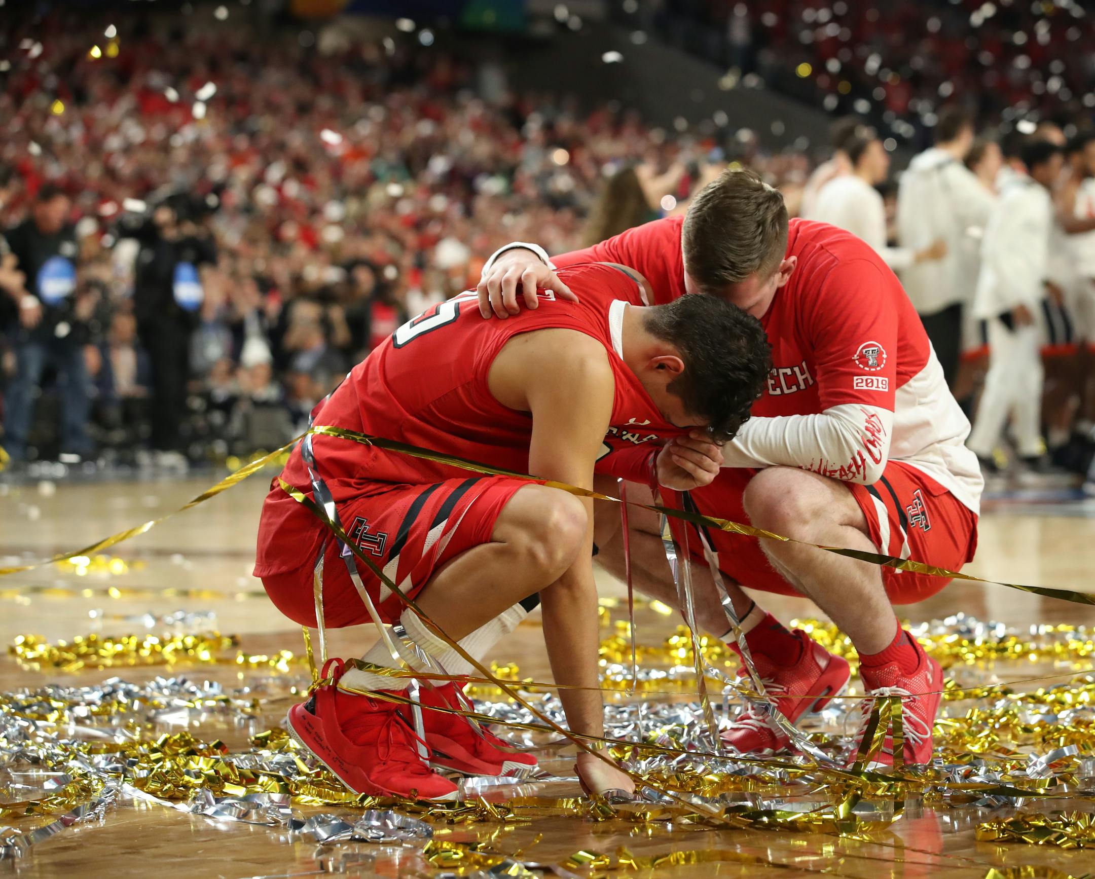 Texas Tech guard Davide Moretti, left, is consoled by a teammate after losing to Virginia.