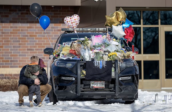 Zach Osterberg, of the Savage Fire Department, was overwhelmed with emotion and hugged his son Lincoln Osterberg as they paid their respect on three m