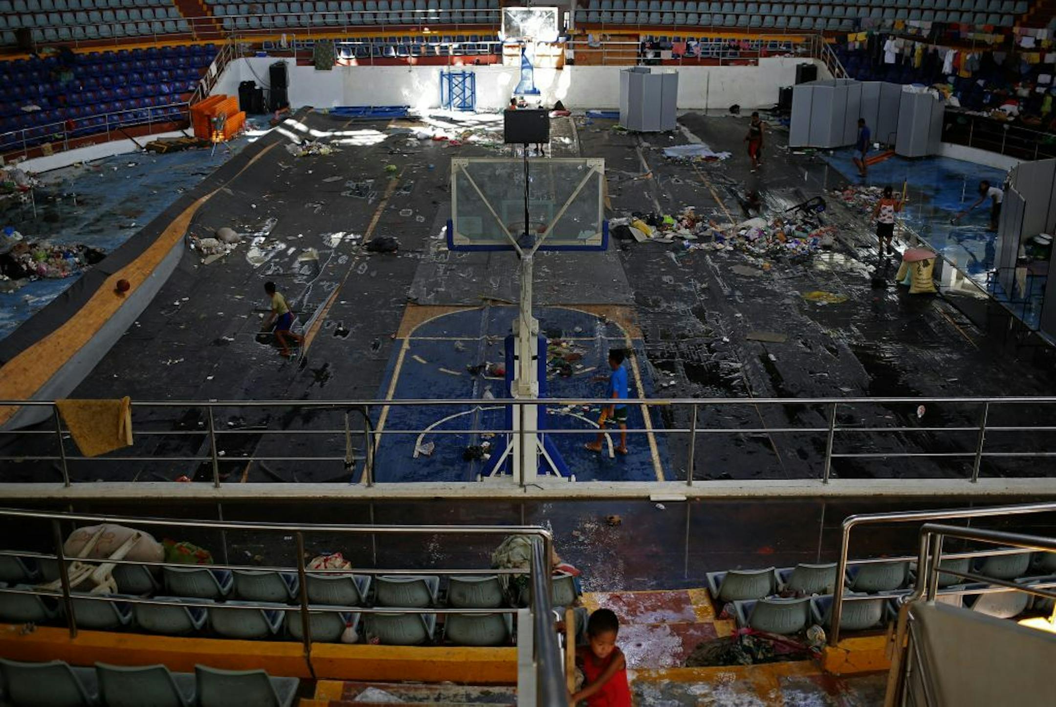 A typhoon survivor sits inside the Tacloban City Convention Center known as the Astrodome Thursday, Nov. 14, 2013.
