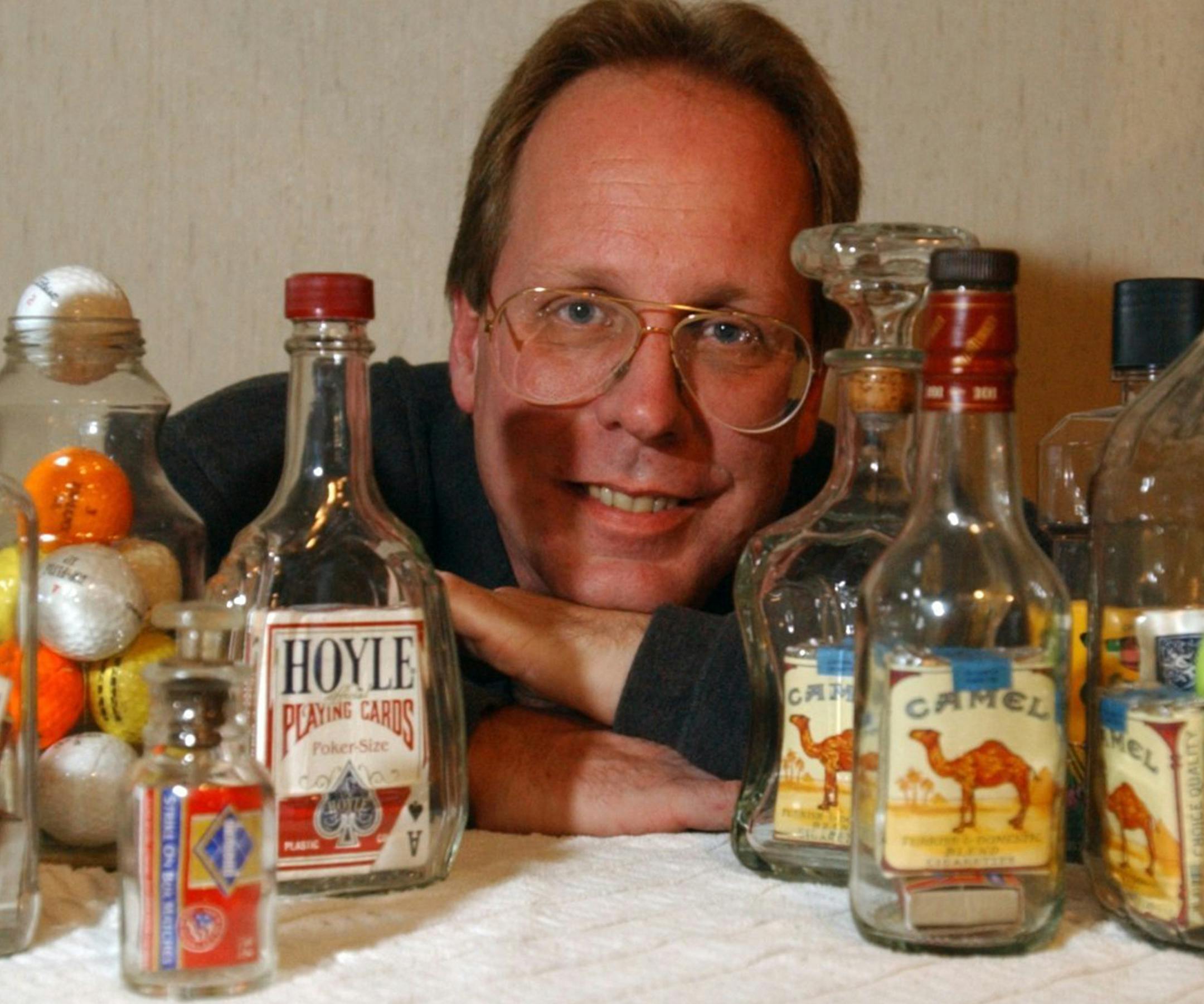 Chris Brown poses with what he calls "Impossible Bottles" he makes by hand on Oct. 22, 2002. (Nabil K. Mark/Centre Daily Times/TNS) ORG XMIT: 1163803