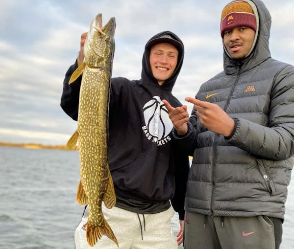 Luke Loewe, left, is getting Gophers teammate Eric Curry hooked on his other sport.