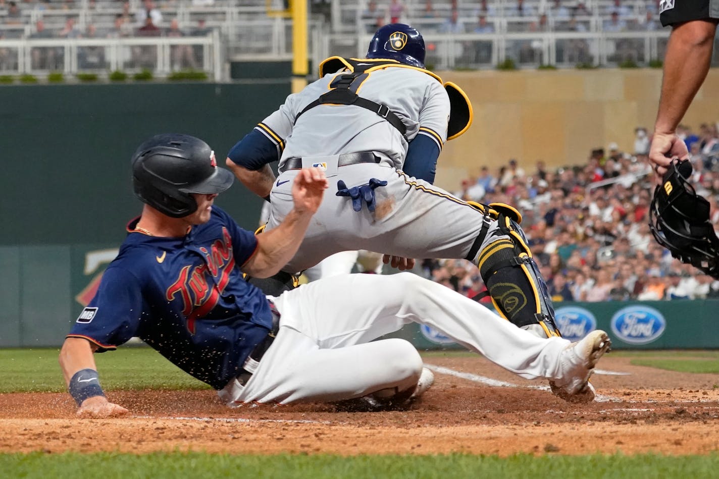 Minnesota Twins' Max Kepler, left, is forced out at home by Milwaukee Brewers catcher Manny Pina on a fielder's choice hit into by Brent Rooker with the bases loaded in the fourth inning of a baseball game Saturday, Aug. 28, 2021, in Minneapolis. (AP Photo/Jim Mone)